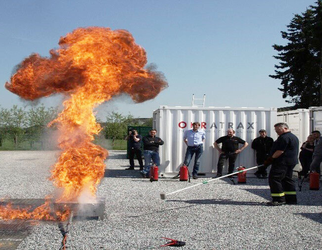 Teilnehmer bei einer praktischen Löschübung mit einem Feuerlöscher